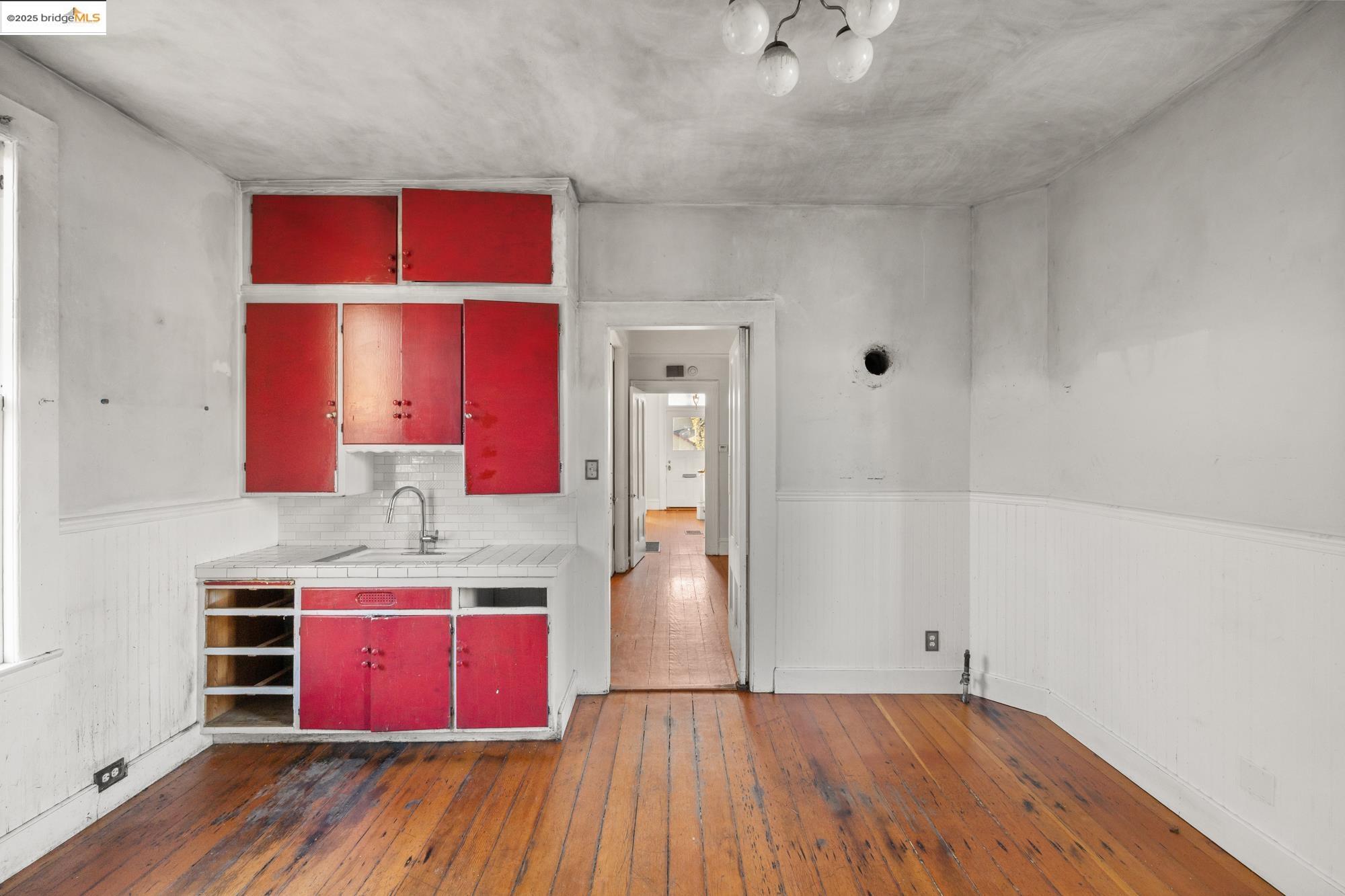1746 8th Street Oakland, CA 94607 - Photo 11 of 52 a kitchen with stainless steel appliances granite countertop a red stove top oven a sink with wooden floors