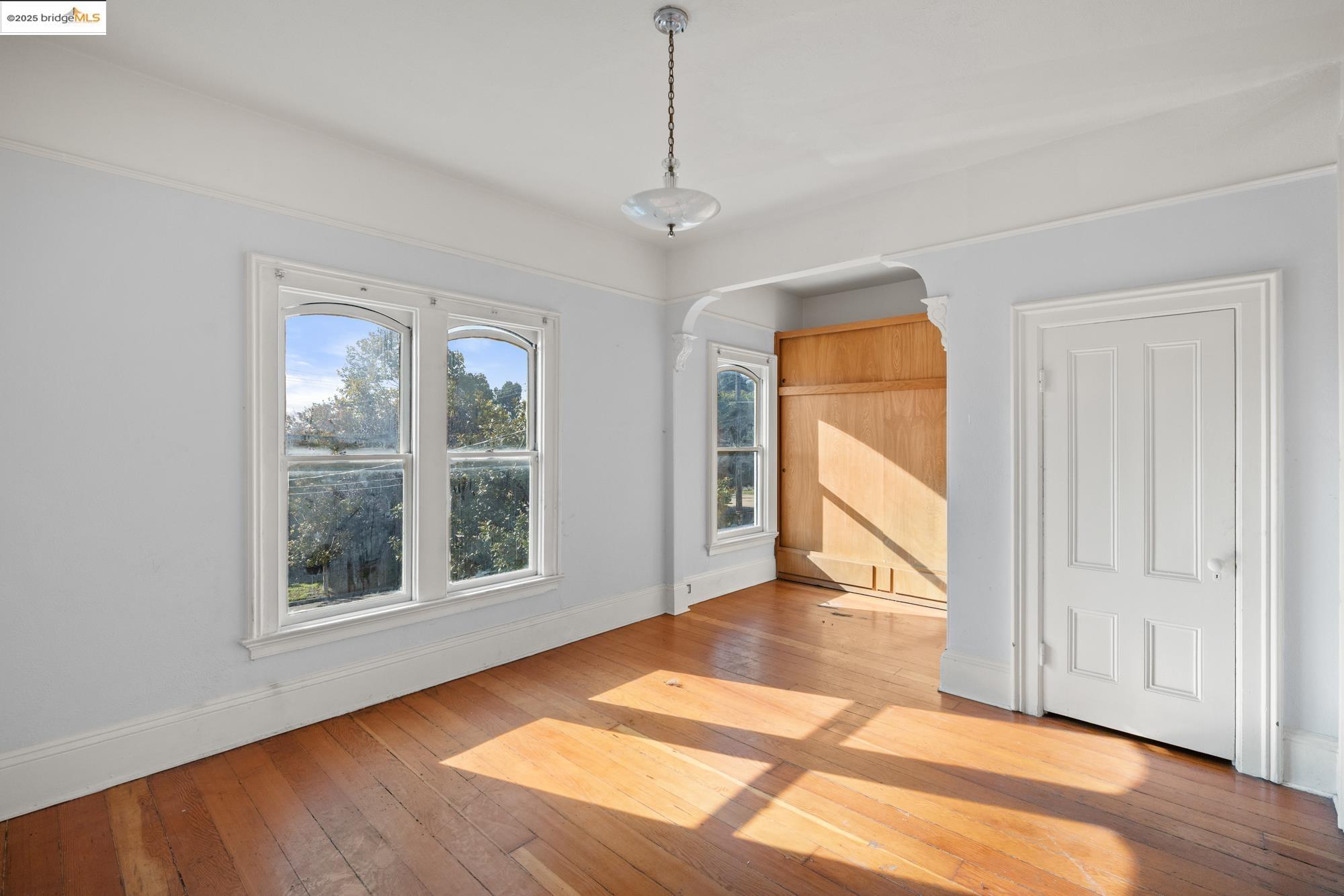 1746 8th Street Oakland, CA 94607 - Photo 19 of 52 a view of an empty room with a window and wooden floor