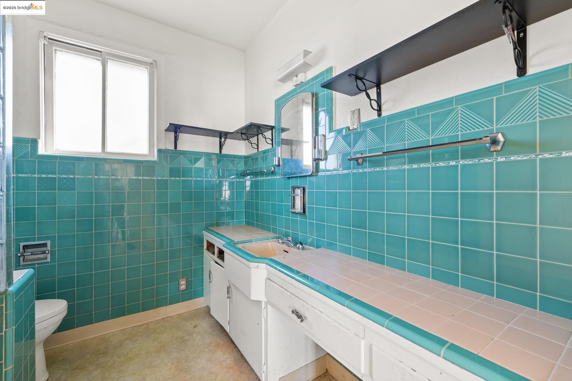 1746 8th Street Oakland, CA 94607 - Photo 21 of 52 a bathroom with a sink and mirror
