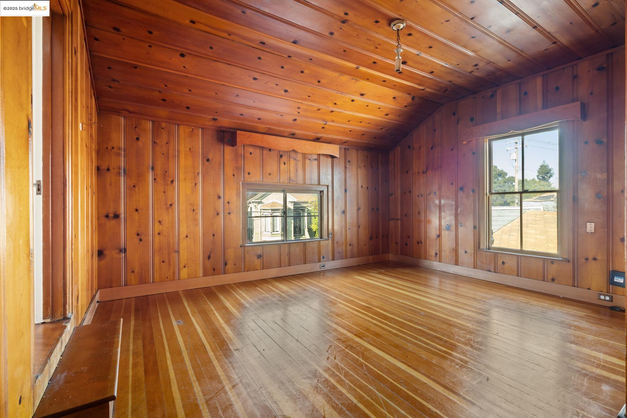 1746 8th Street Oakland, CA 94607 - Photo 26 of 52 an empty room with wooden floor and windows