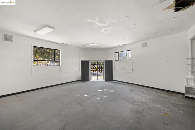 an empty room with windows and closet