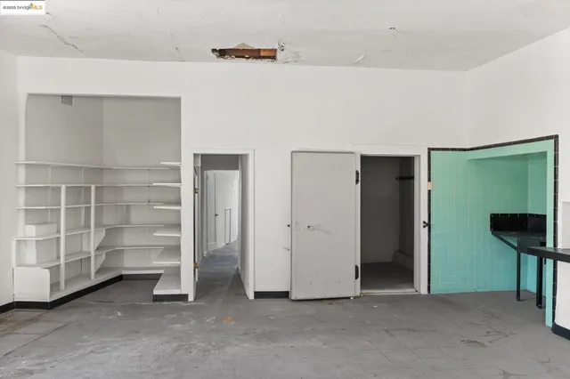 a view of an empty room with cabinet and a window