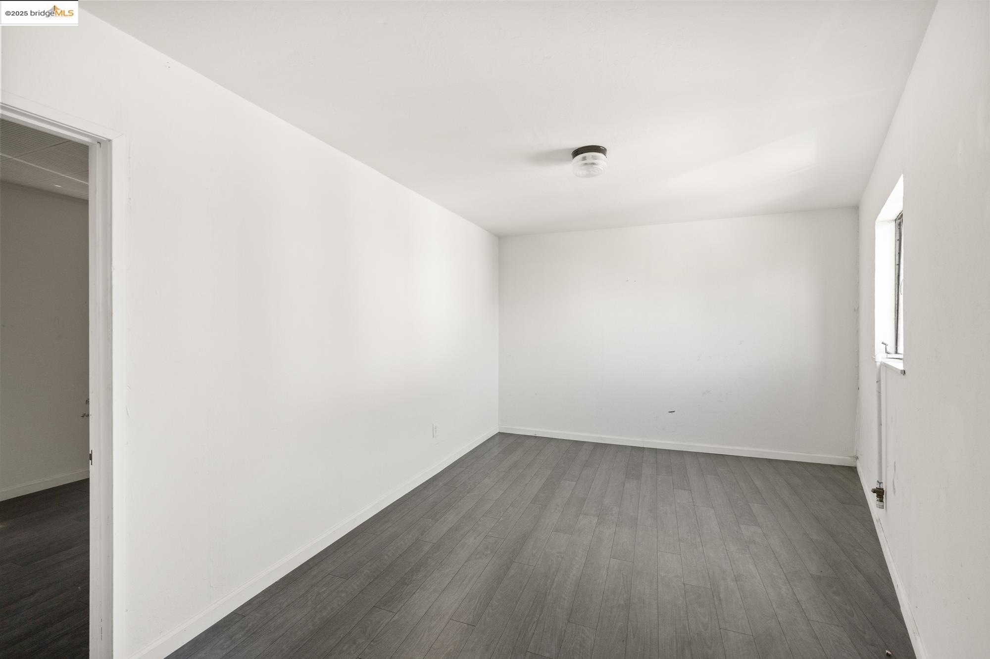 1746 8th Street Oakland, CA 94607 - Photo 40 of 52 an empty room with wooden floor and windows