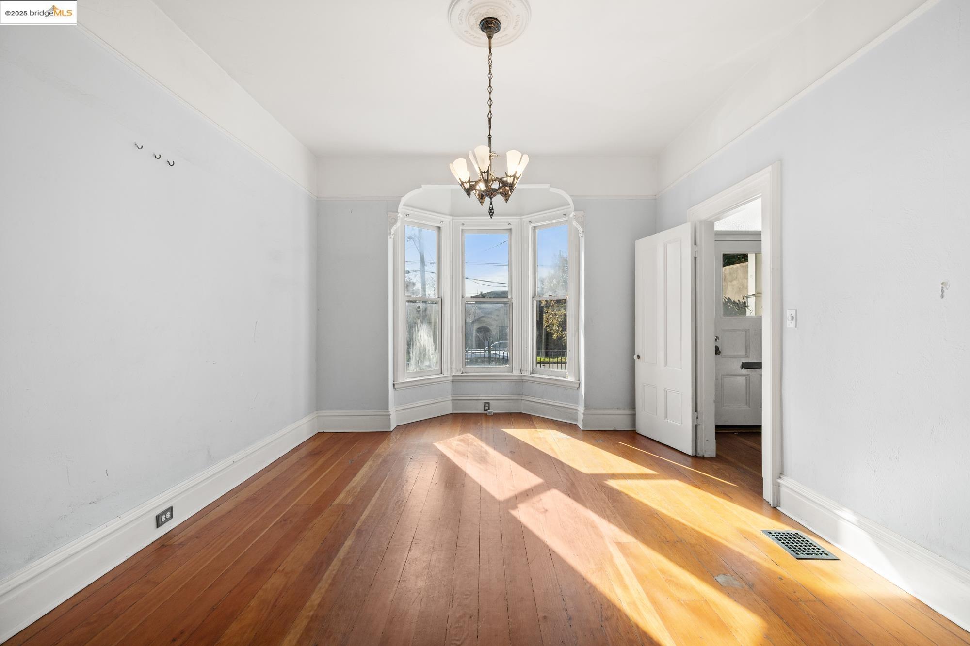 1746 8th Street Oakland, CA 94607 - Photo 4 of 52 a view of an empty room with window and wooden floor