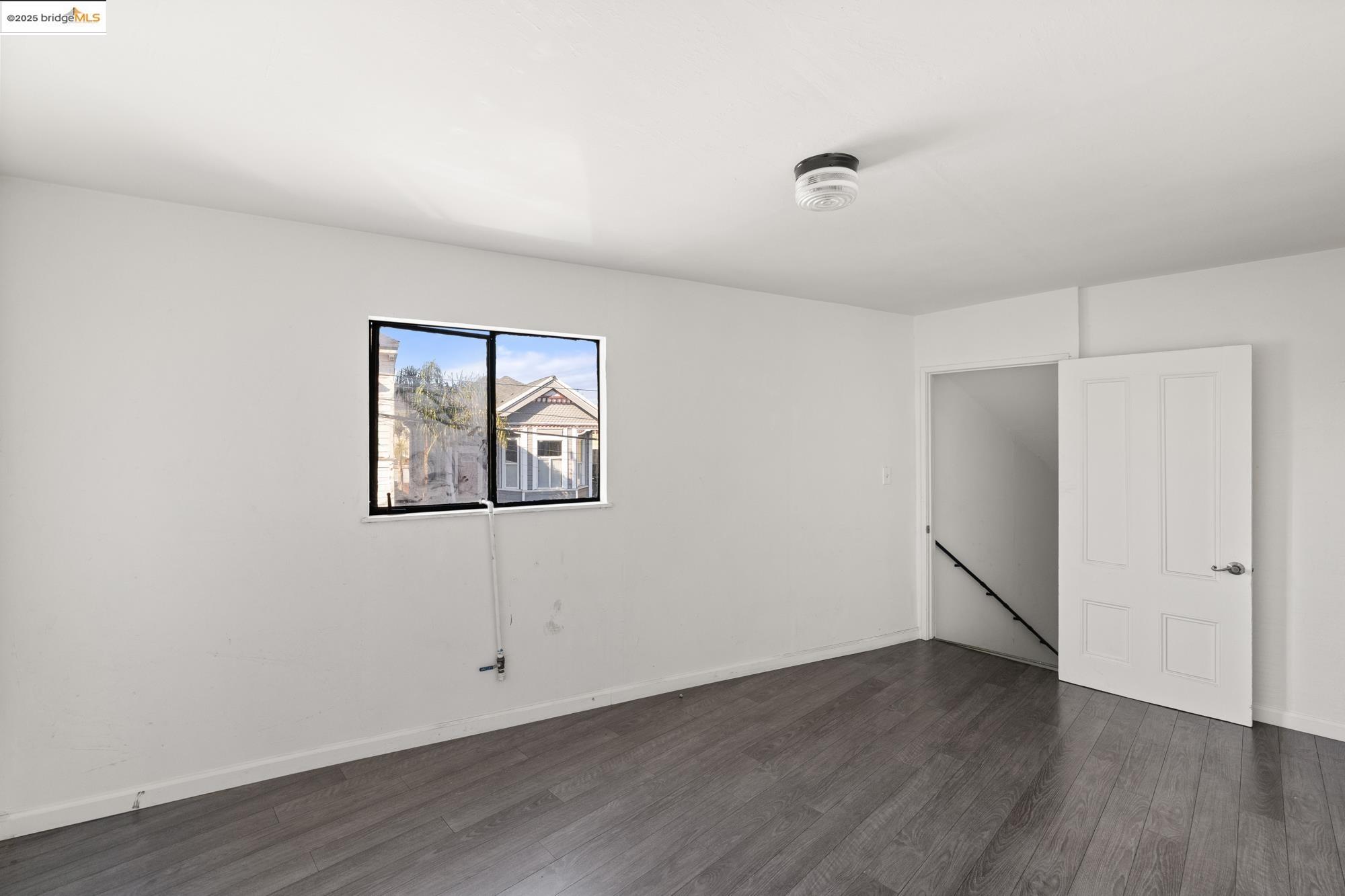1746 8th Street Oakland, CA 94607 - Photo 41 of 52 an empty room with wooden floor and window