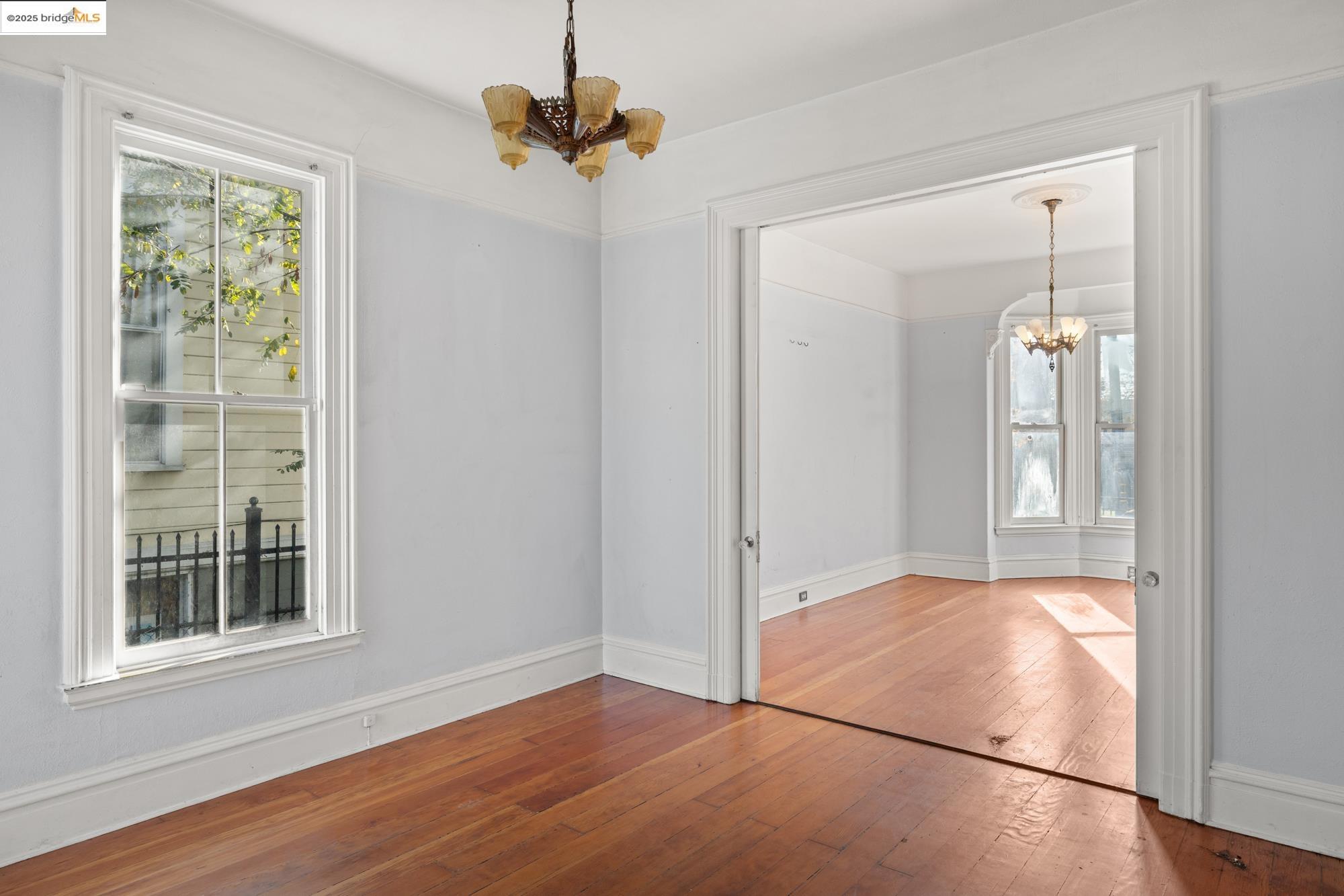 1746 8th Street Oakland, CA 94607 - Photo 6 of 52 an empty room with wooden floor fan and windows
