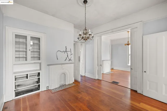 a hallway with white walls and chandelier