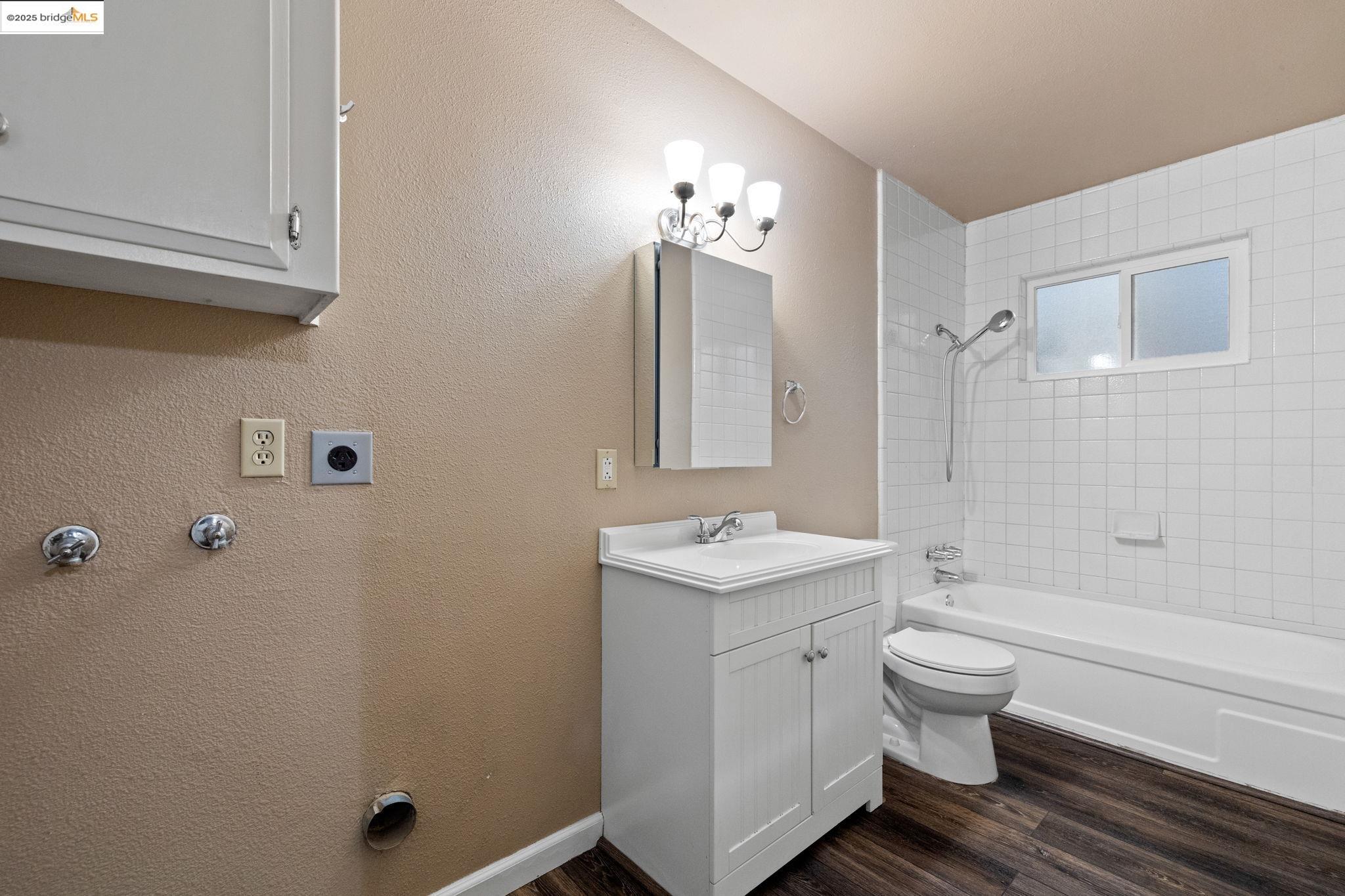 17943 Plateau Road Sonora, CA 95370 - Photo 6 of 11 Bathroom with dark wood-type flooring, shower / washtub combination, a textured wall, and vanity