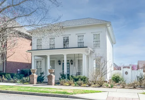 front view of a brick house with a yard