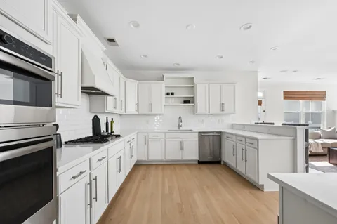 a kitchen with granite countertop appliances sink and cabinets