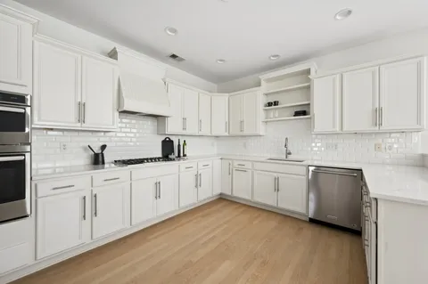 a kitchen with granite countertop white cabinets white stainless steel appliances with a sink and dishwasher