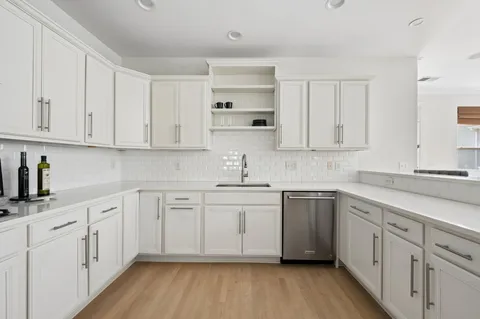 a kitchen with white cabinets stainless steel appliances and sink