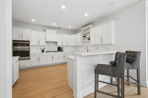 a kitchen with kitchen island white cabinets and stainless steel appliances