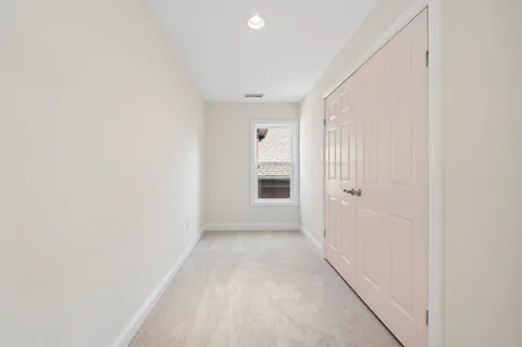 a view of a hallway with wooden floor and a window