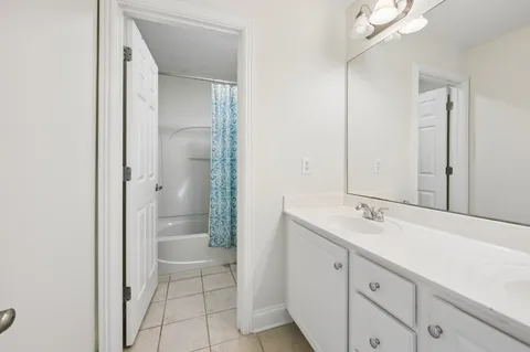 a spacious bathroom with a granite countertop sink mirror and shower