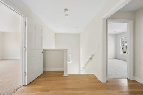 a view of empty room with wooden floor and entryway