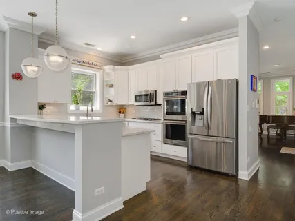 a kitchen with refrigerator cabinets and wooden floor