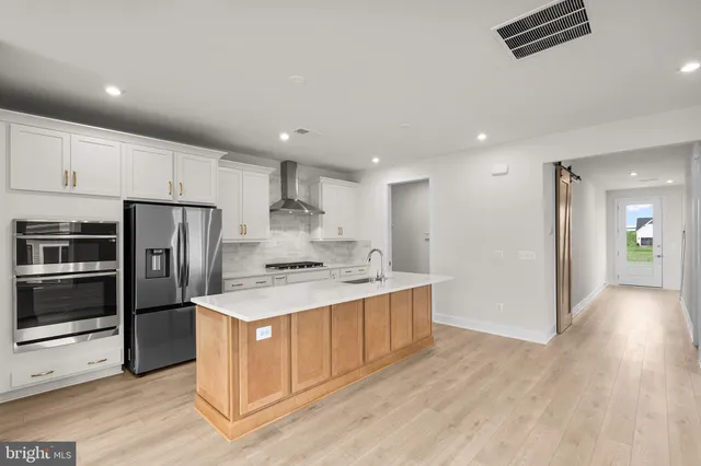 a kitchen with stainless steel appliances a refrigerator and a stove top oven