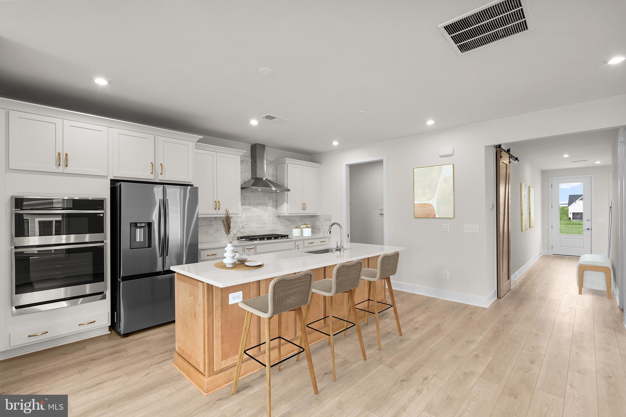 116 Keystone Lane, Unit HOMESITE 1097 Winchester, VA 22603 - Photo 2 of 42 a kitchen with stainless steel appliances kitchen island granite countertop a refrigerator a stove a sink a dining table and chairs