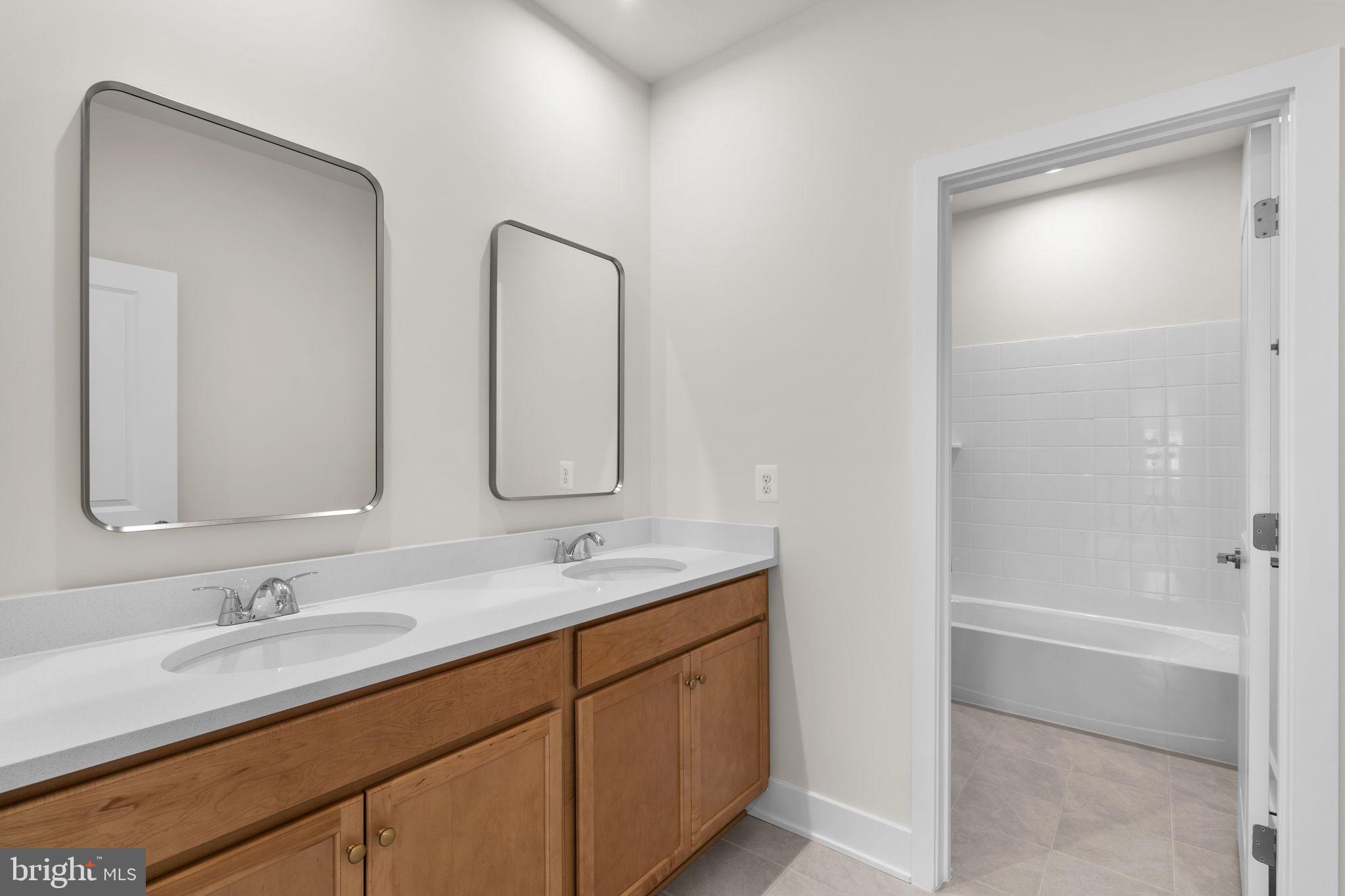 116 Keystone Lane, Unit HOMESITE 1097 Winchester, VA 22603 - Photo 29 of 42 a bathroom with a double vanity sink mirror and shower