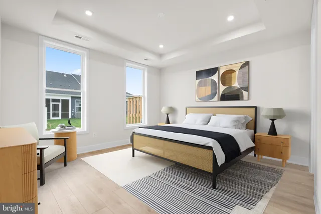 a spacious bedroom with a bed and wooden floor