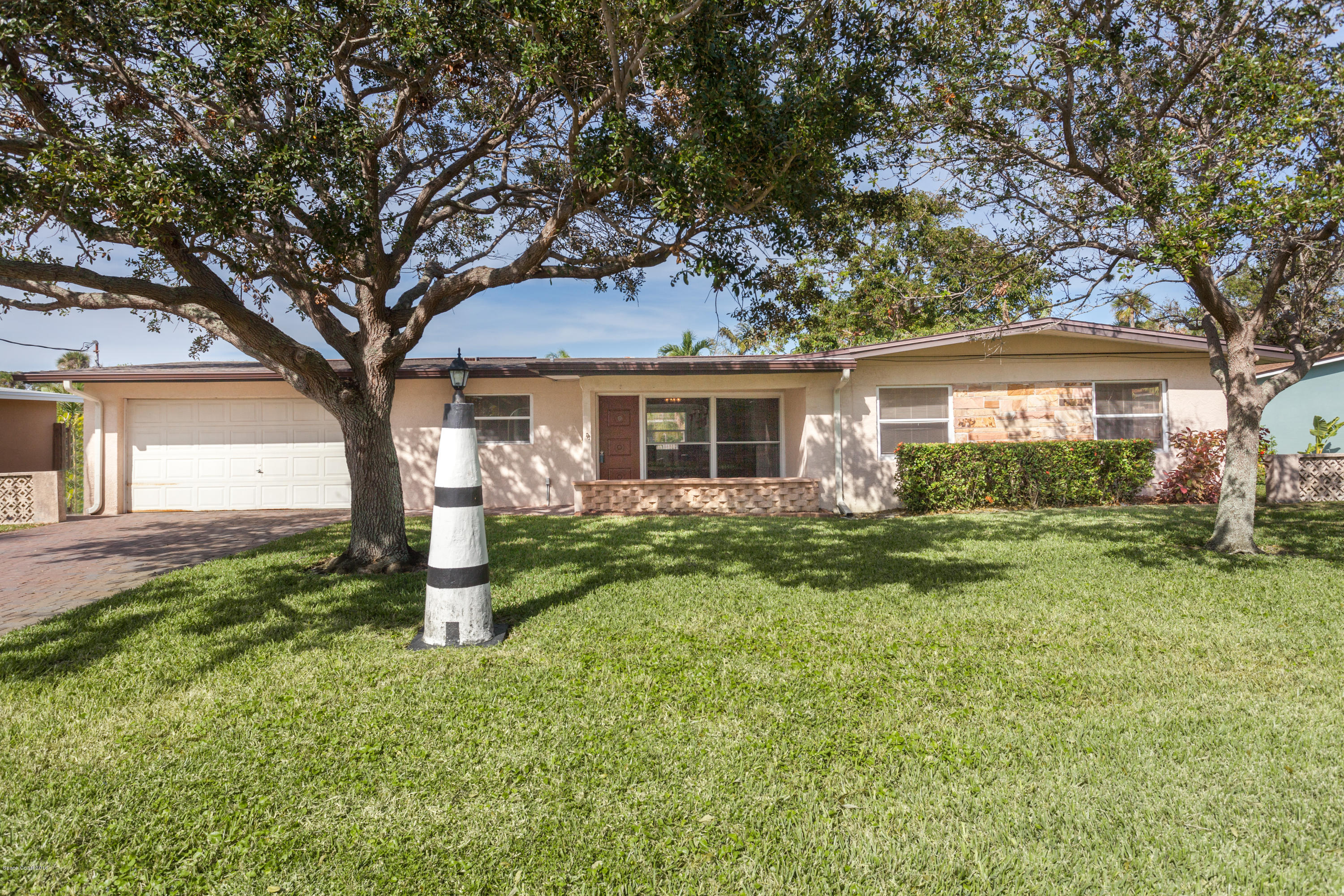 1035 Trinidad Road Cocoa Beach, FL 32931 - Photo 2 of 23 a front view of a house with garden