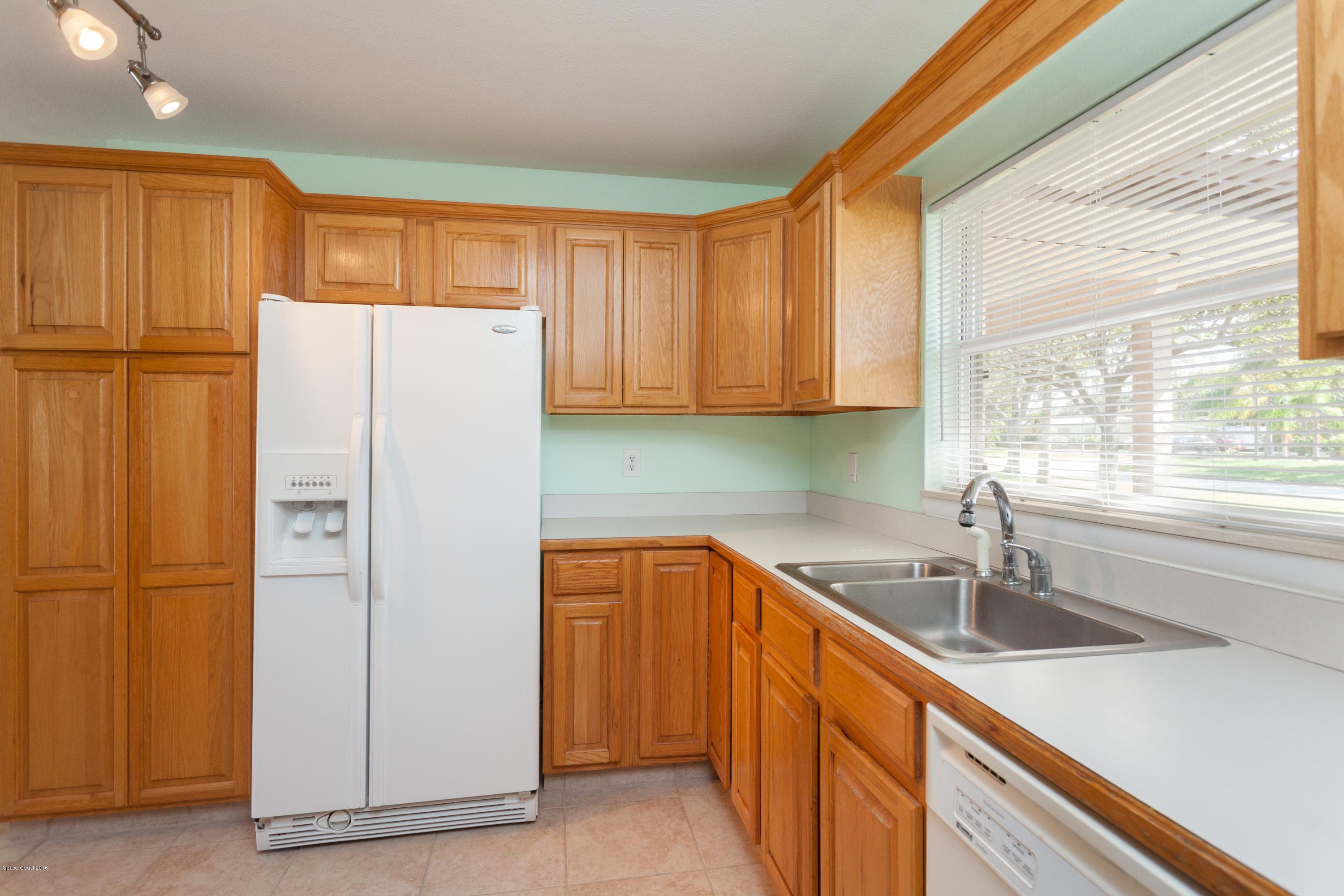 1035 Trinidad Road Cocoa Beach, FL 32931 - Photo 11 of 23 a kitchen with stainless steel appliances granite countertop a refrigerator and a sink
