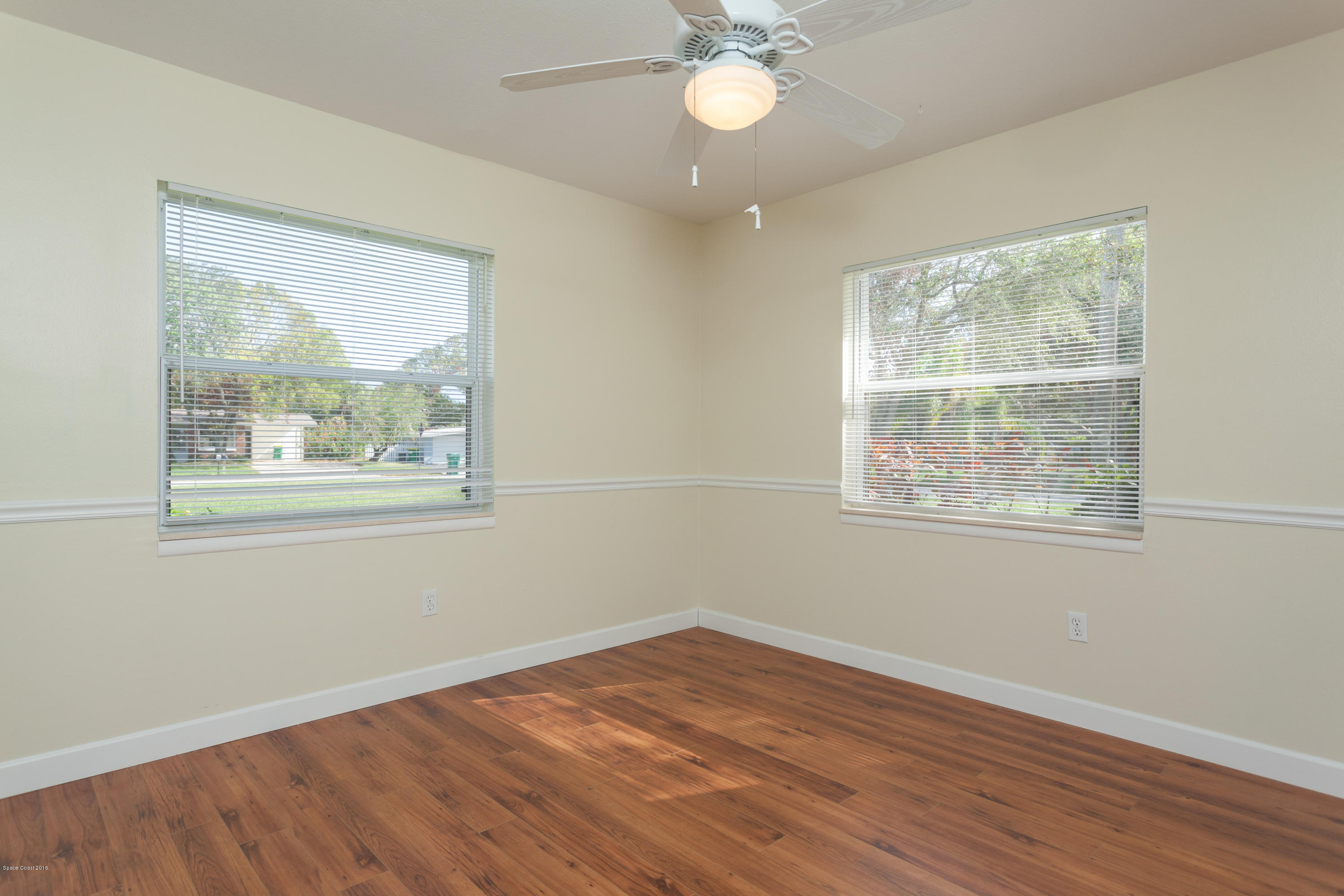 1035 Trinidad Road Cocoa Beach, FL 32931 - Photo 17 of 23 a view of empty room with wooden floor and fan