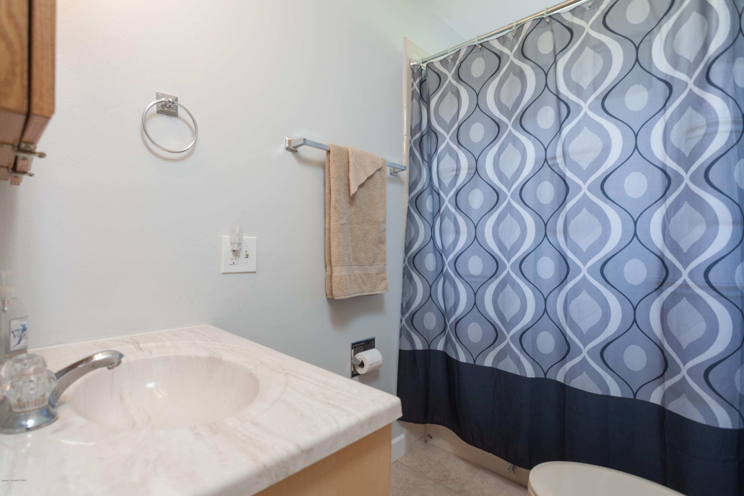 1035 Trinidad Road Cocoa Beach, FL 32931 - Photo 20 of 23 a bathroom with a sink and mirror with toilet