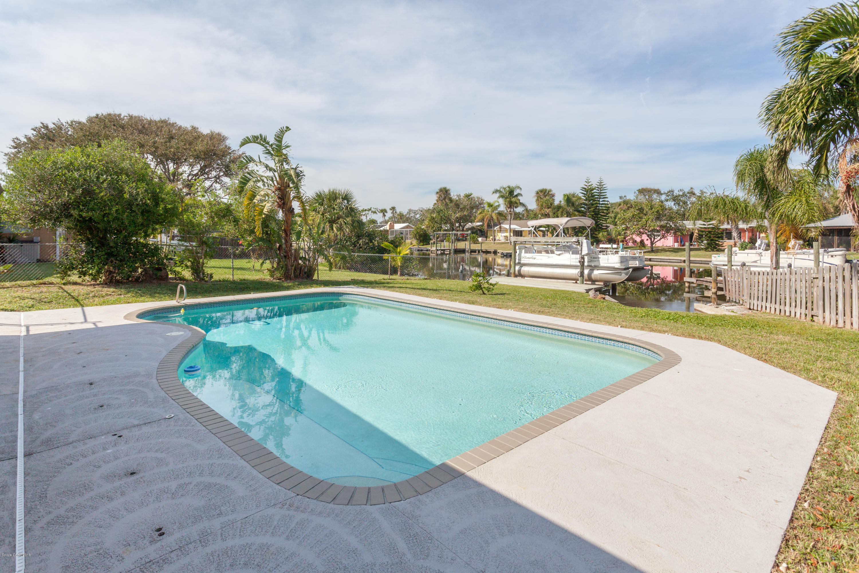 1035 Trinidad Road Cocoa Beach, FL 32931 - Photo 21 of 23 a view of a swimming pool with an outdoor seating and a yard