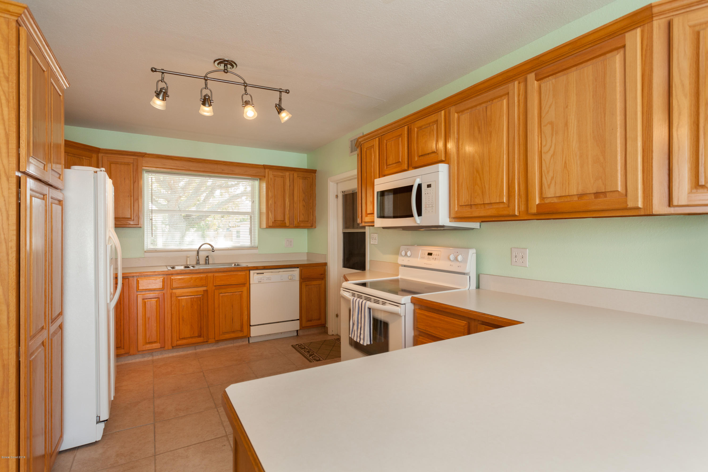 1035 Trinidad Road Cocoa Beach, FL 32931 - Photo 9 of 23 a kitchen with stainless steel appliances granite countertop a refrigerator a stove top oven a sink and dishwasher with wooden floor