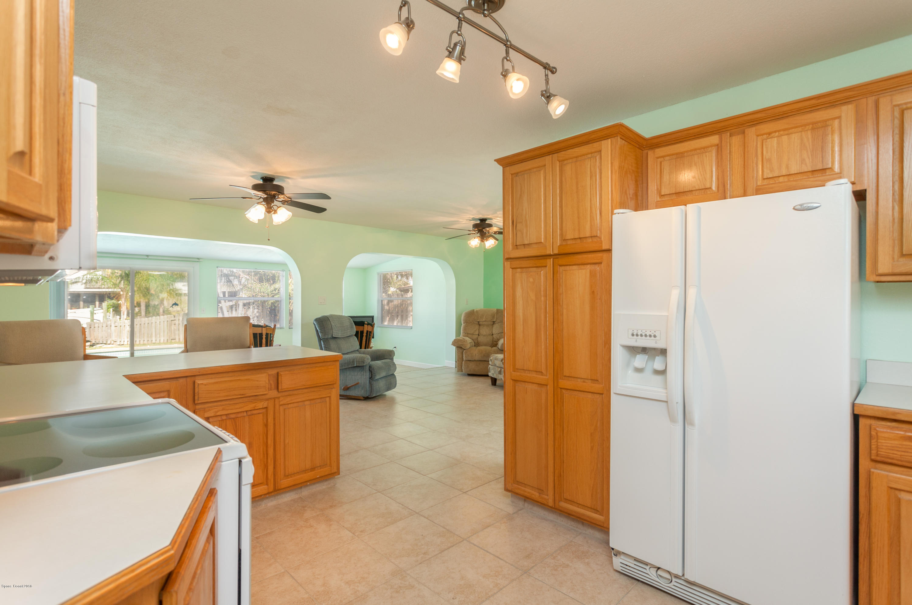 1035 Trinidad Road Cocoa Beach, FL 32931 - Photo 10 of 23 a kitchen with refrigerator a sink and cabinets