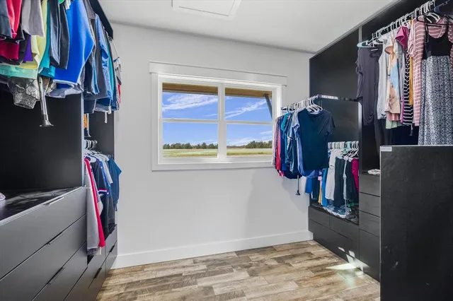 a view of walk in closet with clothes and shoes