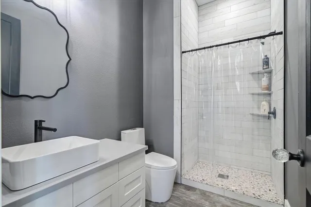 a bathroom with a shower toilet and sink