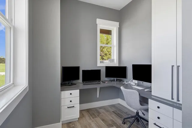 a view of a workspace with furniture and a window