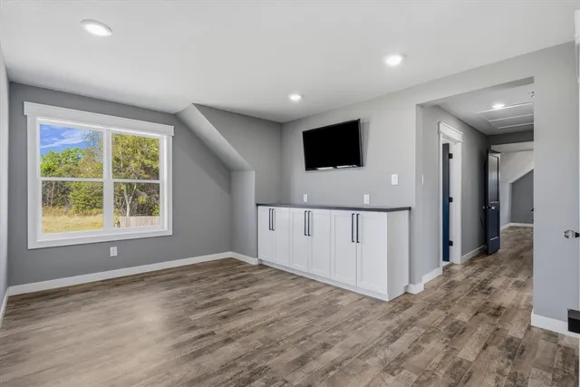 en empty room with window and wooden floor