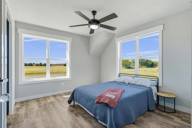 a view of a big room with wooden floor and windows