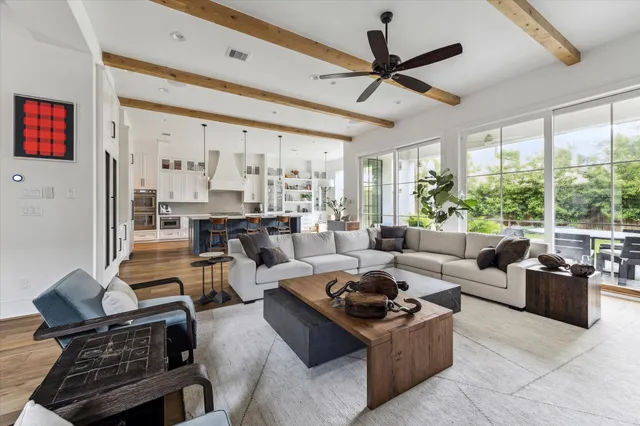 a living room with furniture ceiling fan and a large window