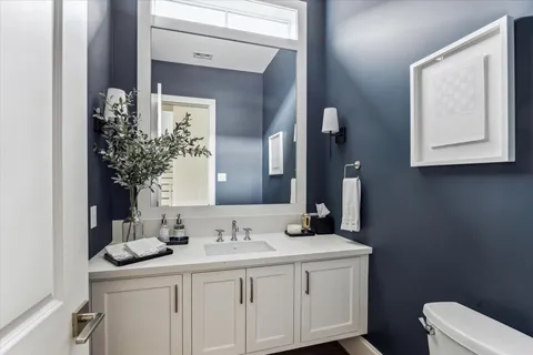 a bathroom with a toilet sink and mirror