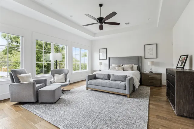 a living room with furniture ceiling fan and a large window