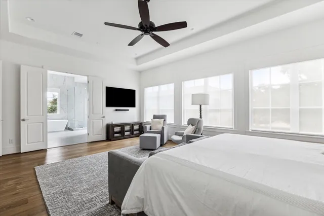 a large bedroom with a large bed a flat screen tv and a couch