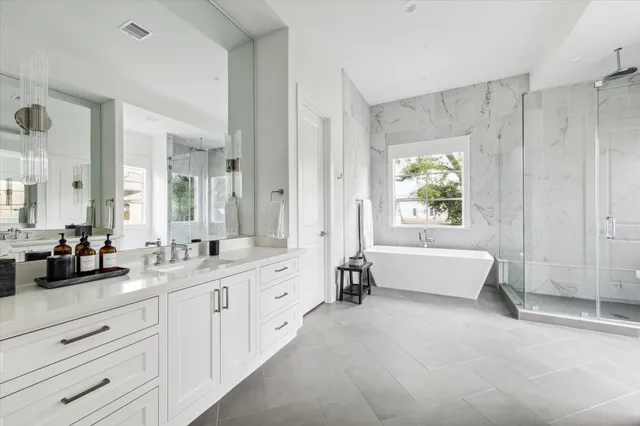 a spacious en suite bathroom with a granite countertop tub and 2 sink