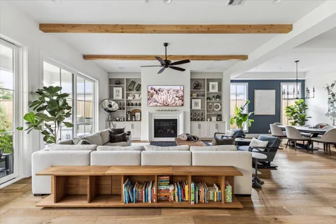 a living room with fireplace furniture and a large window