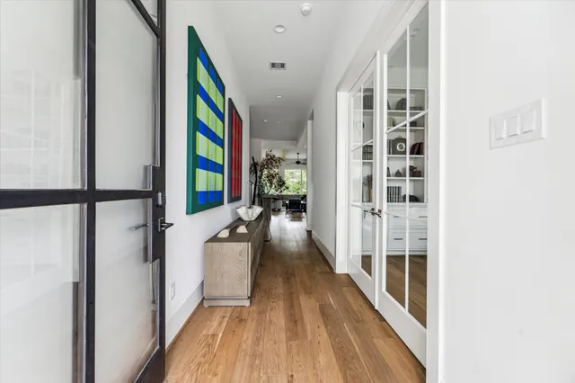 a view of a hallway with wooden floor and staircase