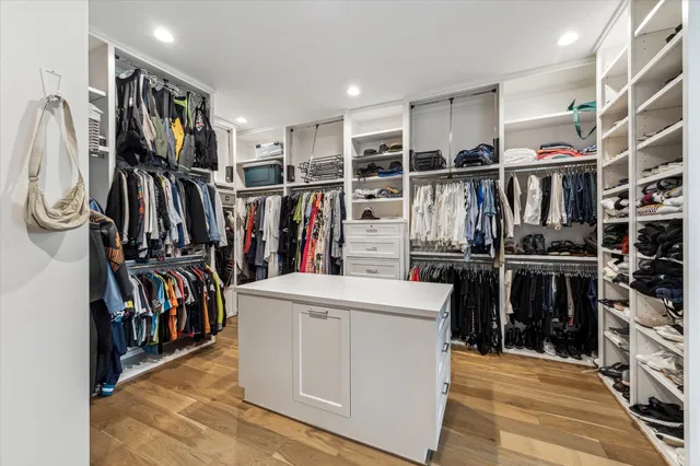 a view of walk in closet with clothes and shoes