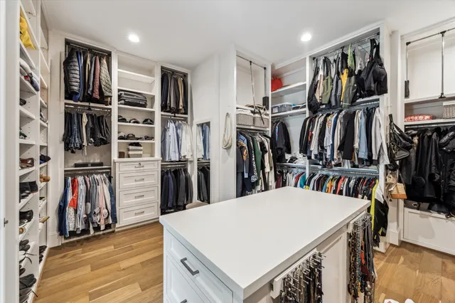 a view of walk in closet with clothes and shoes