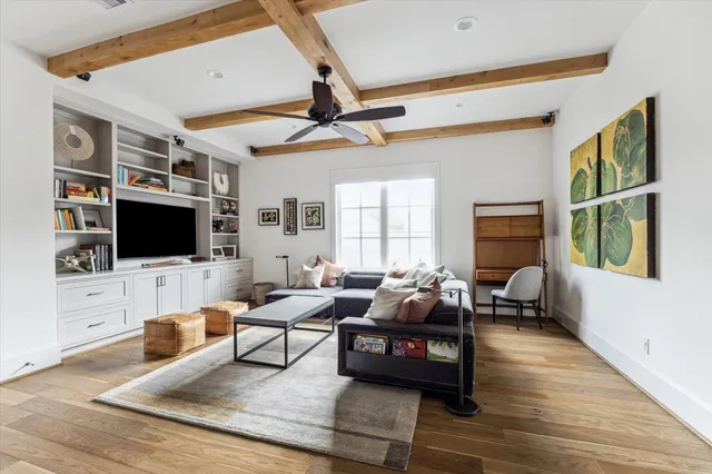 a living room with furniture a flat screen tv and a floor to ceiling window