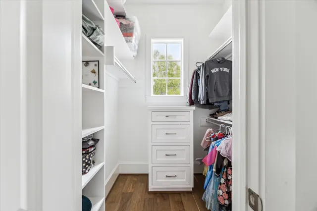 a view of walk in closet with clothes and shoes