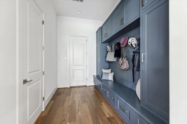 a view of a hallway with wooden floor and a living room