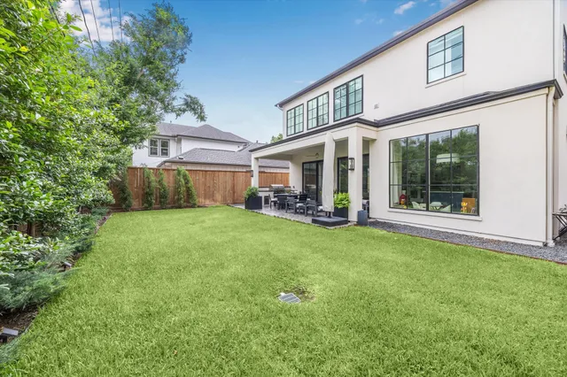 a view of a house with a big yard and large tree